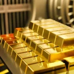 Barrinhas de ouro empilhadas em prateleira dentro de um cofre de banco, simbolizando reservas monetárias nacionais e segurança econômica.
