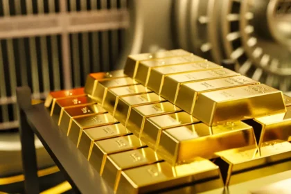 Barrinhas de ouro empilhadas em prateleira dentro de um cofre de banco, simbolizando reservas monetárias nacionais e segurança econômica.