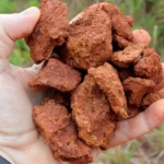 Uma imagem de Jazida de Bauxita, com seu aspecto terroso e avermelhado.